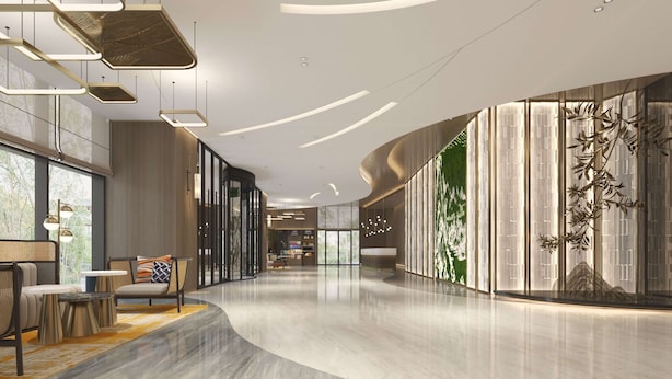A spacious lobby with a curved floor, modern lighting fixtures, and a large wall with a vertical garden. - Hilton Garden Inn Hangzhou Xiaoshan (Hangzhou)