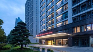 A modern hotel with a prominent entrance, multiple floors, and a well-lit facade. - Hilton Garden Inn Hangzhou Xiaoshan (Hangzhou)