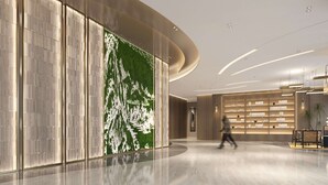 A spacious lobby with a curved ceiling, a large wall with a green vertical garden, and a seating area with a wooden table and chairs. - Hilton Garden Inn Hangzhou Xiaoshan (Hangzhou)