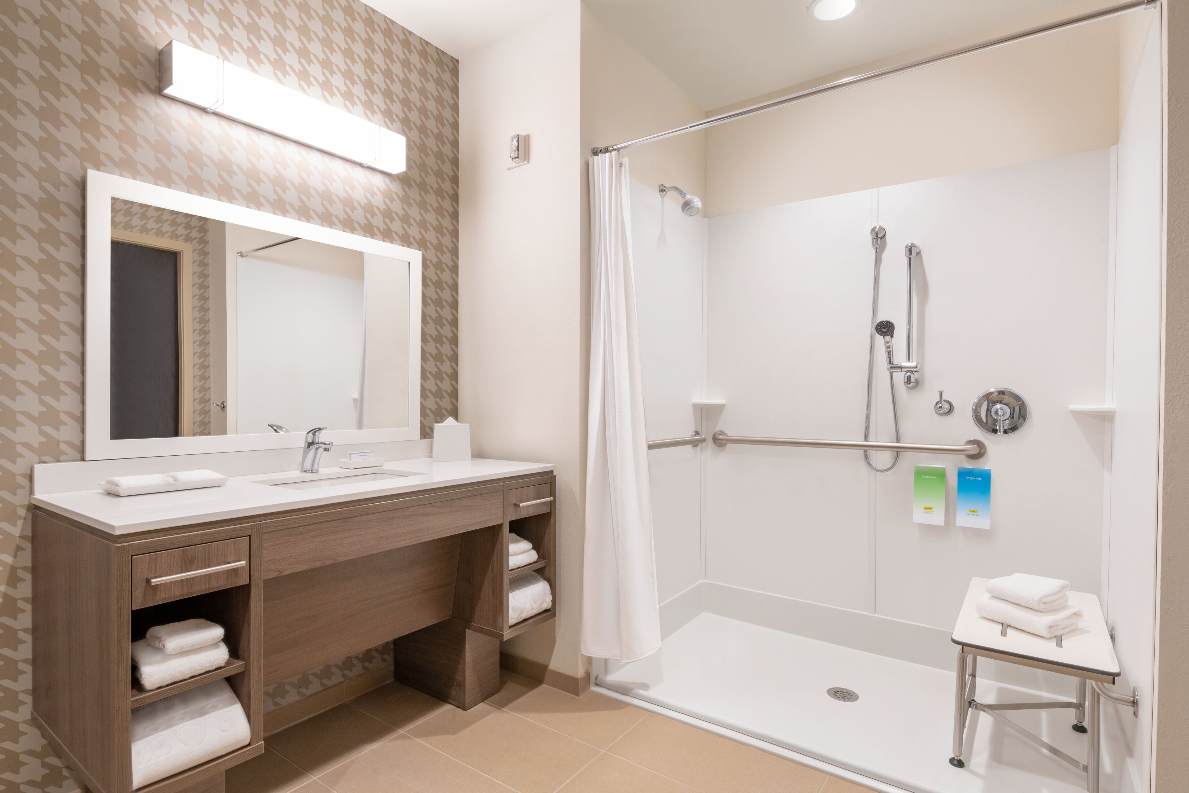 Een moderne badkamer met een douche, wastafel en badmeubel.