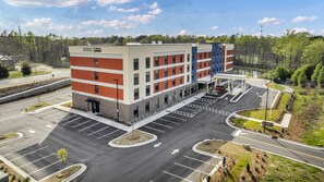 A multi-story hotel with a parking lot and a gas station.