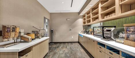 A modern kitchen with wooden cabinets, a white countertop, and a tiled floor.