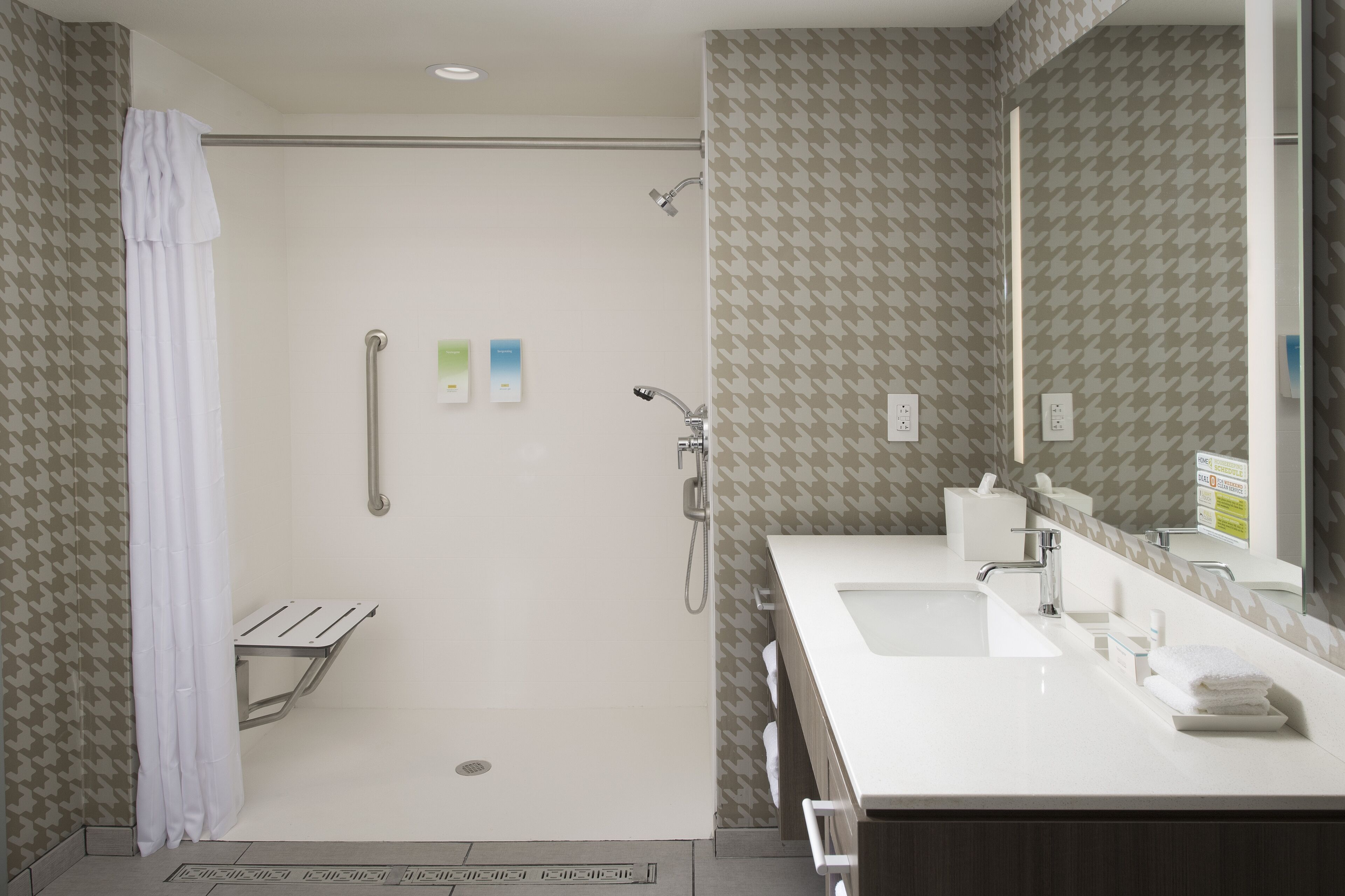 Une salle de bain moderne avec une douche, un lavabo et un miroir.