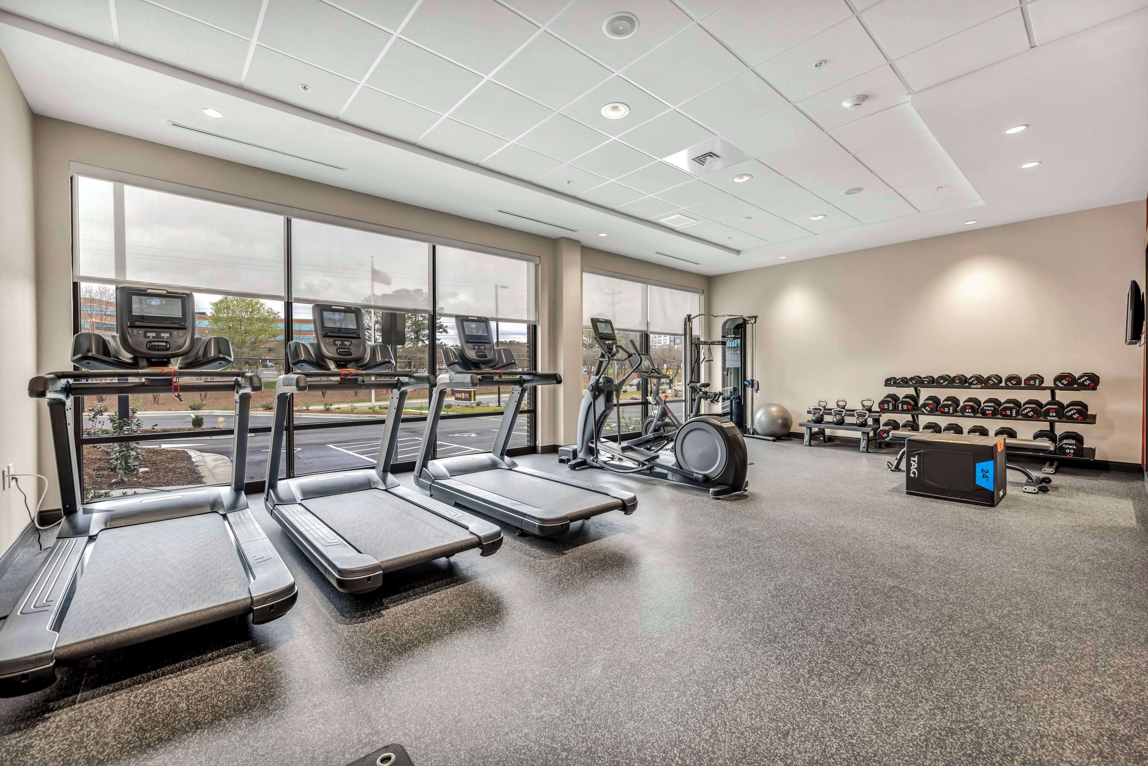 A gym with treadmills, an elliptical, and a weight rack.