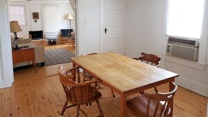 A dining area with a wooden table and chairs, a ceiling fan, and a window with blinds. - Miss Niccies - 2BR home close to town, Lg Screened porch. NO LINENS PROVIDED (Chincoteague)