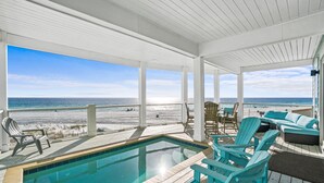 A covered outdoor area with a pool, chairs, and a view of the beach. - Beach House - Sweet n Salty by PHG (Panama City Beach)