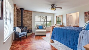 A bedroom with a bed, a chair, a fireplace, and a ceiling fan. - La Roca - Clifton/Valley Mills/Meridian (Valley Mills)