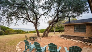 A backyard with Adirondack chairs, a brick house, and a view of the landscape. - La Roca - Clifton/Valley Mills/Meridian (Valley Mills)
