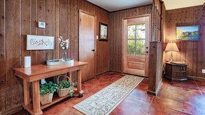 A wooden-paneled hallway with a wooden console table, a rug, and a lamp. - La Roca - Clifton/Valley Mills/Meridian (Valley Mills)