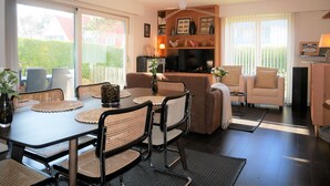A modern living room with a dining area, a sofa set, a TV, and a fireplace. - Isabelle A1 - Bright family apartment with sunny terrace - in the concession (De Haan)
