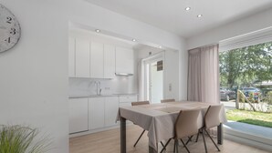 A modern kitchen with white cabinets and a dining area with a table and chairs.