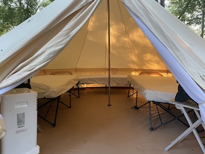 A tent with two beds, a white refrigerator, and a portable heater. - Son's Guadalupe Glamping Tent A (New Braunfels)