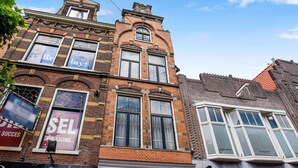 A multi-story building with large windows and a brick facade. - Haarlem Apart Hotel (Haarlem)
