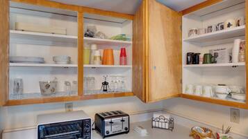 A kitchen with wooden cabinets, a toaster, and various kitchenware.
