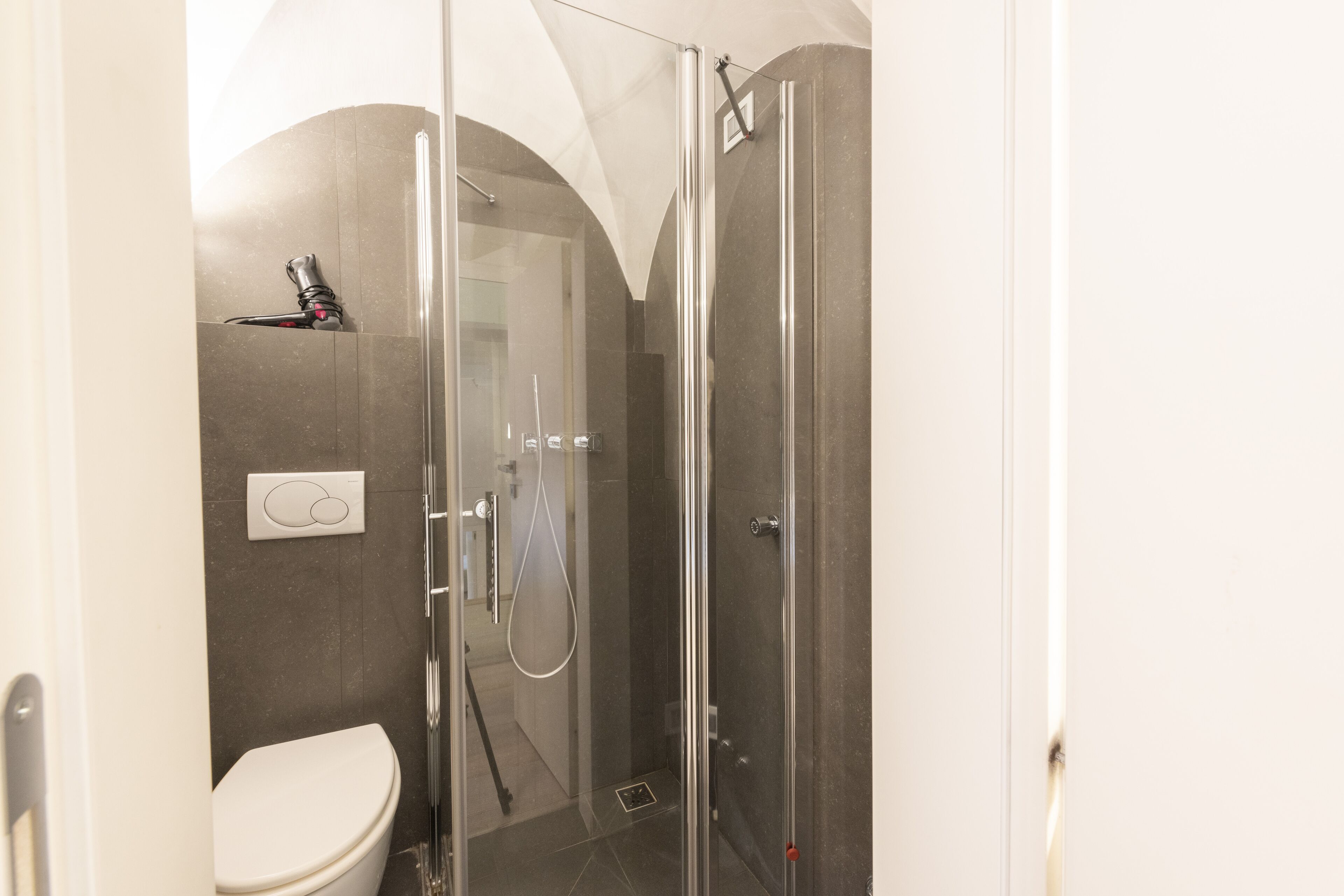 Un baño moderno con ducha de vidrio, inodoro y toallero.