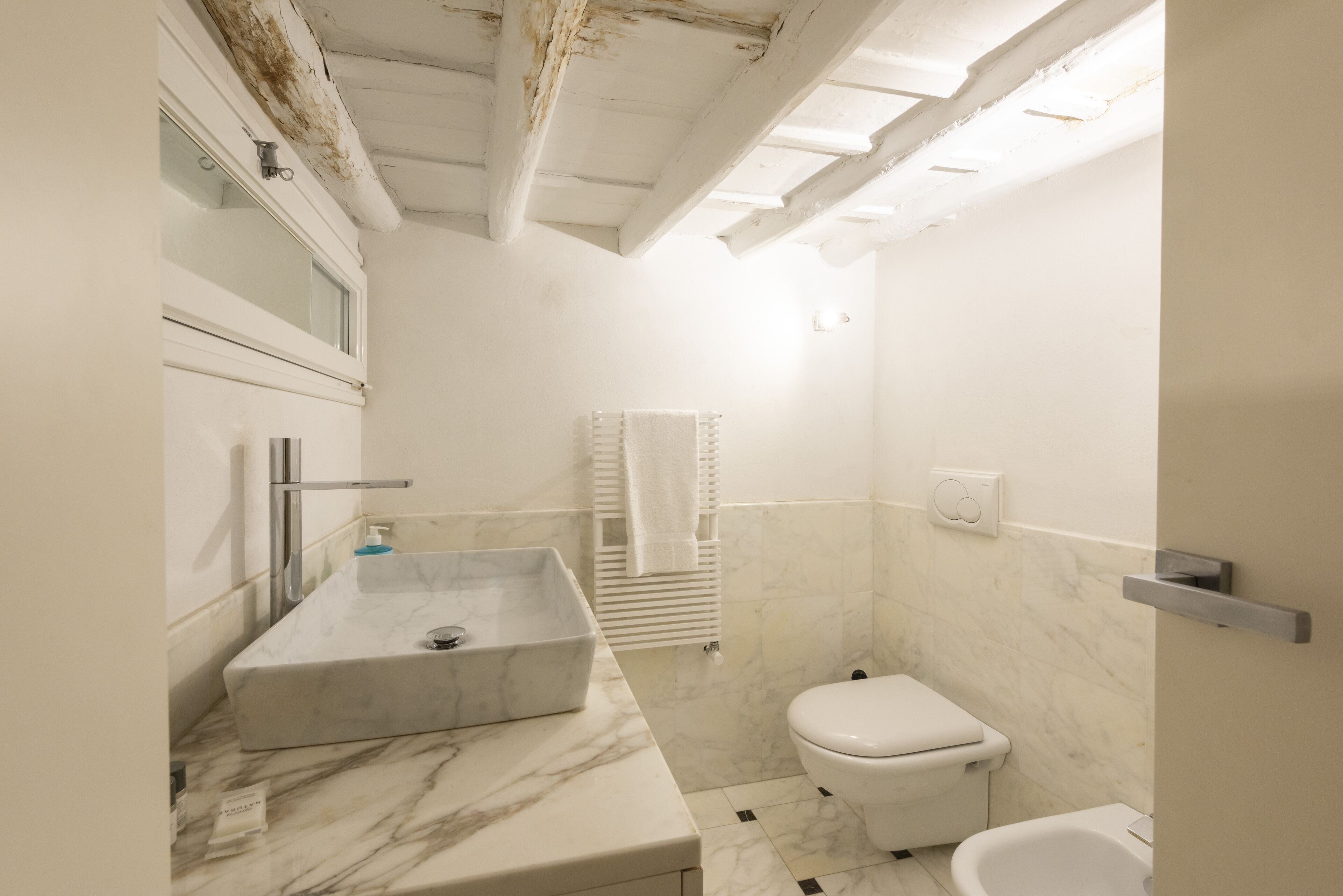 Une salle de bain avec un lavabo en marbre, des toilettes et une baignoire.