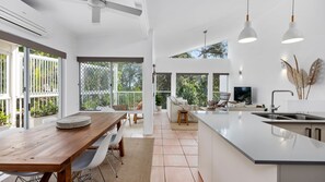 Enjoy meals and relaxation in this spacious kitchen and dining area with a large island, dining table, and cozy seating area.