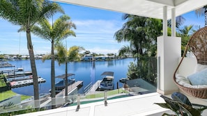 Enjoy a serene view of the marina from this balcony, featuring a wicker chair and small table.