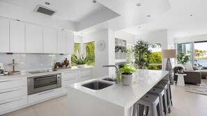 Enjoy cooking in this well-equipped kitchen with a large island, oven, and sink, surrounded by natural views.