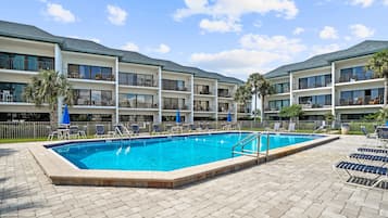 Una piscina al aire libre de temporada, sombrillas