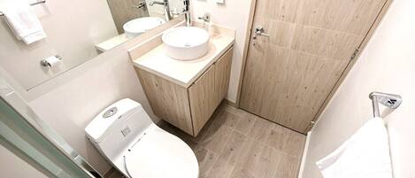 A modern bathroom with a toilet, sink, and mirror.