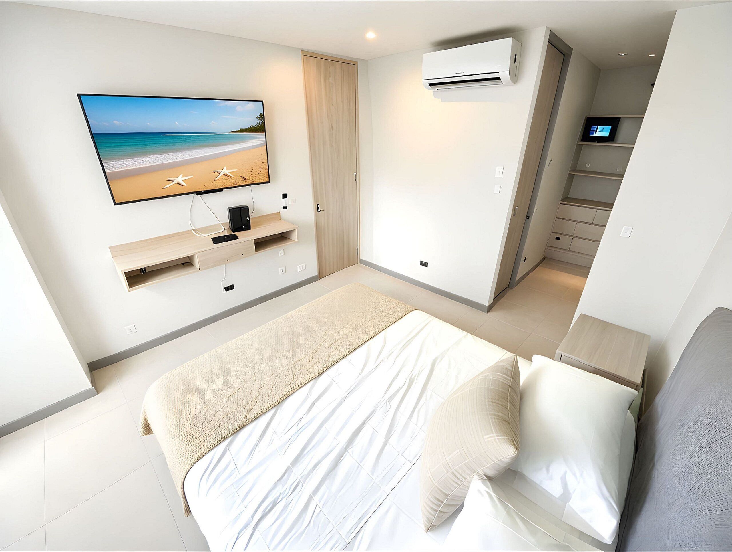 Un dormitorio moderno con cama, televisor montado en la pared, armario empotrado y unidad de aire acondicionado.
