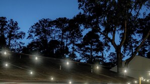 An outdoor patio with wicker furniture, a fire pit, and string lights. - Quiet, convenient & Modern Haven (Gainesville)