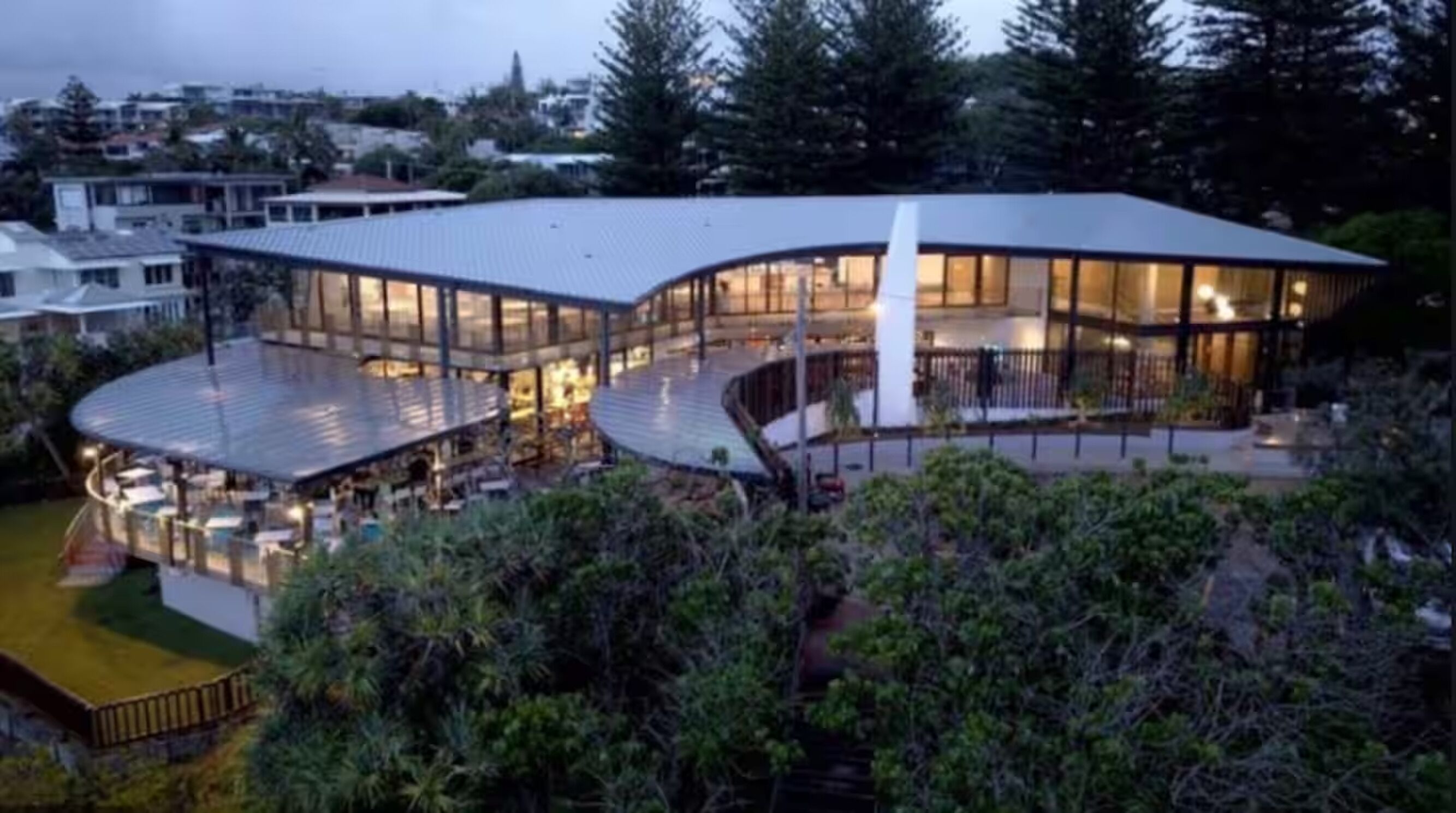 Un bâtiment moderne doté d’un toit incurvé et de grandes fenêtres en verre.