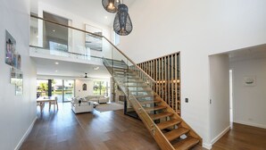 A spacious interior with a modern staircase, a dining area, and a view of the outdoors.