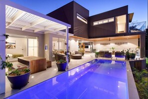 A modern house with a swimming pool, outdoor seating, and a covered patio area. - Absolute Noosa Waterfront -Pool-Gym-Sauna-Pontoon (Noosaville)