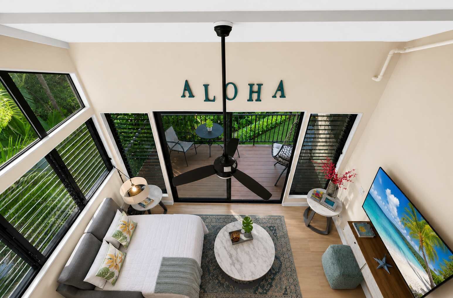 Un salon moderne avec un ventilateur de plafond, un canapé, une table basse et un téléviseur.