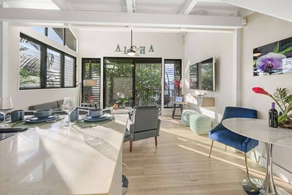 A modern interior with a dining area, a bar, and a seating area with a view of the outdoors.