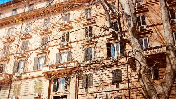 Un immeuble à plusieurs étages, de style architectural classique, doté d’une entrée centrale, de nombreuses fenêtres et de balcons.