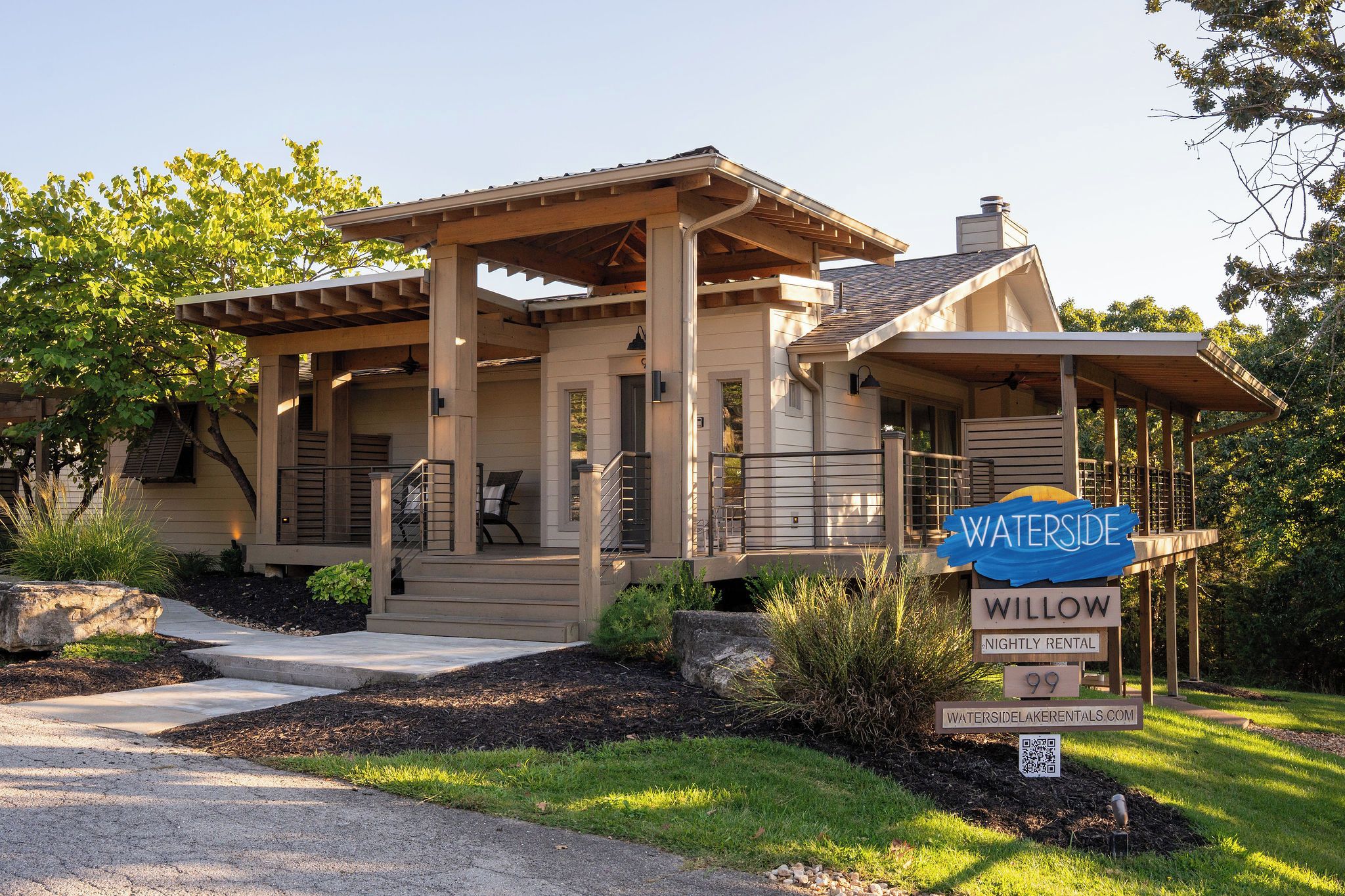 A two-story house with a covered porch, a front entrance, and a sign indicating it is a nightly rental property.