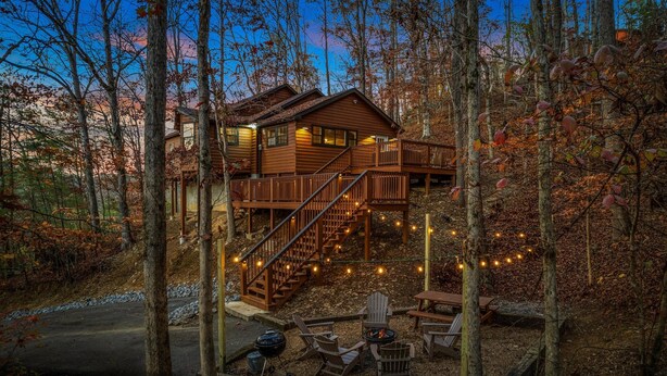 A cabin with a deck, outdoor seating, and a fire pit.