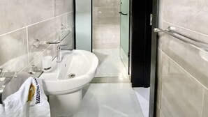 A modern bathroom with a freestanding bathtub, a glass shower enclosure, and a black door. - Harrington court (Lekki)
