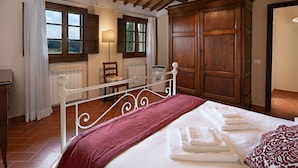 A bedroom with a bed, wooden wardrobe, and a radiator. - Camino, Montauto - Holiday apartment  with pool close to San Gimignano (Montauto)