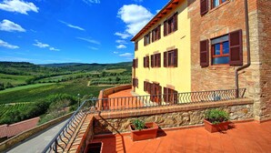 A two-story building with a balcony overlooking a vineyard. - Villa, Montauto - Vacation Villa with pool close to San Gimignano (Montauto)