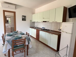 Fridge, stovetop, cookware/dishes/utensils, dining tables - Comfortable Apartment with Beach Service Included (Cropani Marina)
