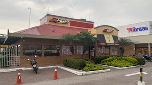 Restaurante Pizza Hut com telhado vermelho e um anúncio para 'TVentas' na rua.