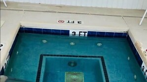 Una piscina de 3 pies con un cartel de 'NO DIVING', paredes con azulejos y escalones que bajan a la piscina.