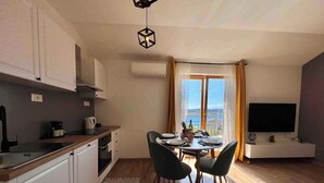 Een moderne keuken met witte kastjes, een houten aanrechtblad en een eethoek met een tafel gedekt voor vier personen.