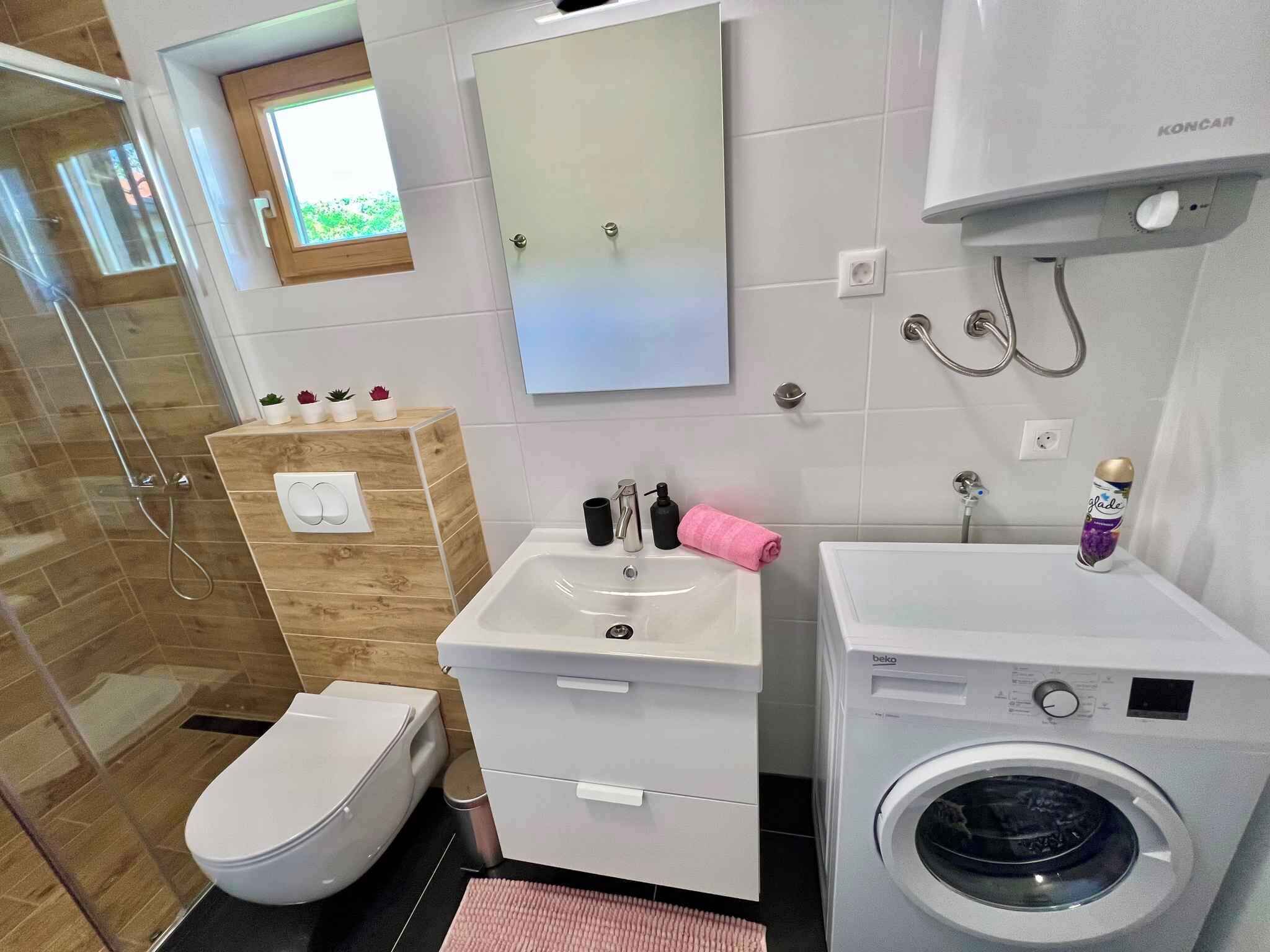 A modern bathroom with a toilet, sink, and washing machine.