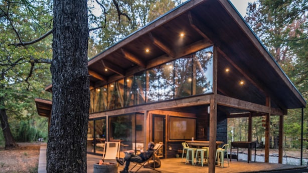 A cabin with a wooden deck, large windows, and a fireplace. - Stylish cabin in Corralco with Hot Tub in the middle of the native forest. (Malalcahuello)