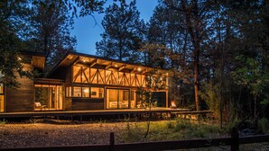 A modern cabin with large windows, a deck, and a fire pit. - Stylish cabin in Corralco with Hot Tub in the middle of the native forest. (Malalcahuello)