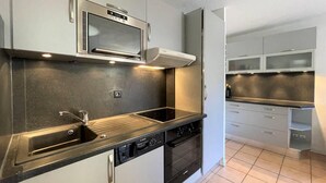 A modern kitchen with stainless steel appliances, a built-in oven, and a dishwasher.