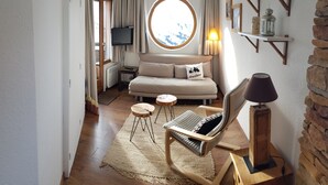 A cozy room with a sofa, a rocking chair, a small table, a TV, and a window with a view. - Studio 4 P ideally located with magnificent view (Morzine)