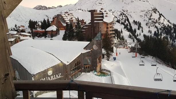 A snow-covered mountain village with traditional wooden buildings, a ski lift, and a wooden building with 'QUATRAZ' signage. - Studio 4 P ideally located with magnificent view (Morzine)