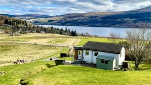 A house with a sloped roof, a front porch, and a small garden. - Ciaran Cottage (Aberfeldy)