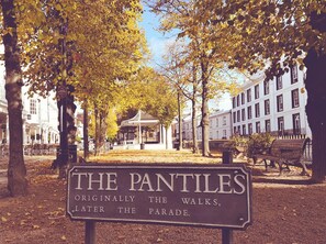 A sign in a park with the text "The Pantiles, Originally the Walks, Later the Parade." - Stylish 1-bed Apartment - Heart of Tunbridge Wells (Royal Tunbridge Wells)